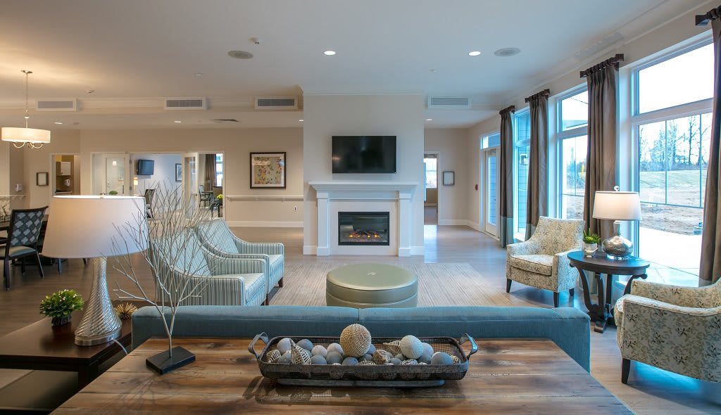 A spacious living room featuring modern furniture, a fireplace, and a television.