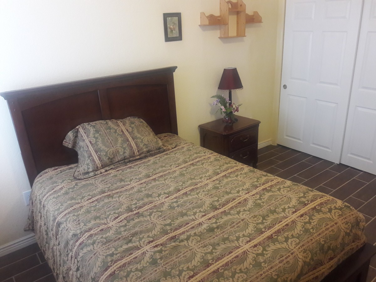 A cozy bedroom with a bed, nightstand, and decorative items.