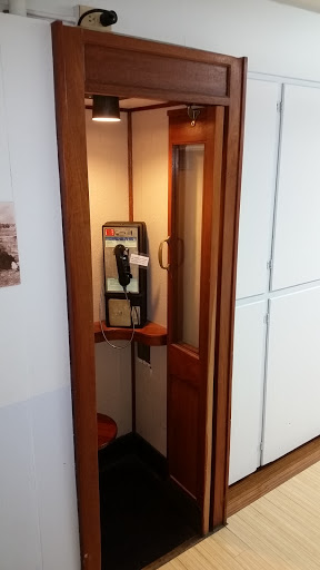 A vintage-style phone booth featuring a public payphone.