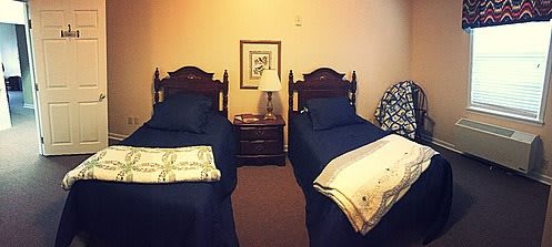 A cozy bedroom with twin beds and a shared nightstand.