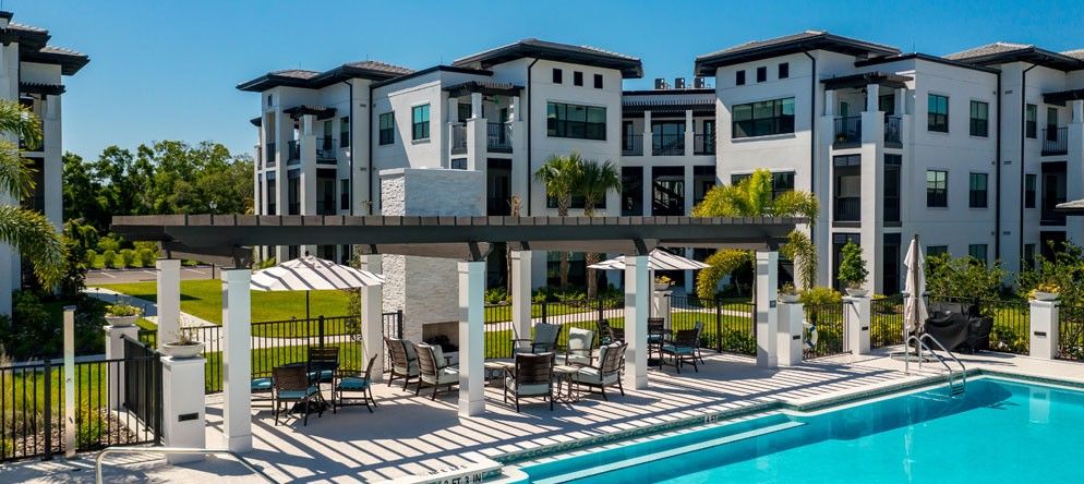 A modern luxury apartment complex featuring a swimming pool and outdoor patio area.
