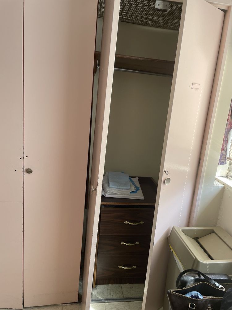 An open wardrobe revealing shelves and hanging space inside.