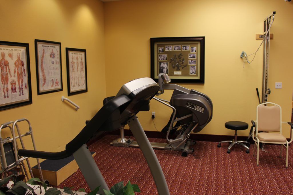 A small gym with exercise equipment, including a treadmill and other fitness machines.