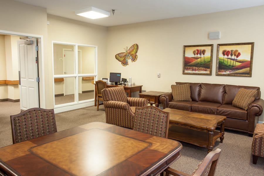 A cozy lobby area with comfortable seating, tables, and decorative artwork on the walls.