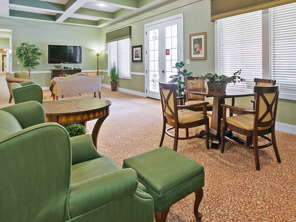 A cozy living room with green furniture and ample natural light.