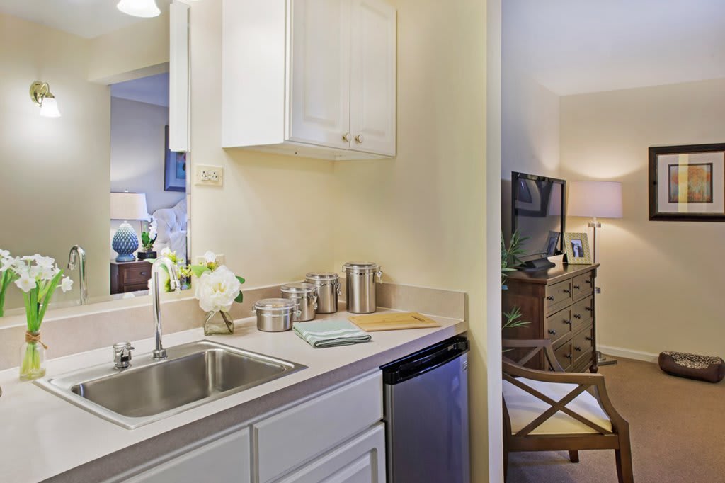 A small, neatly organized kitchen area with a sink and countertop accessories.