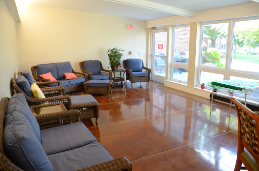 A cozy waiting area with comfortable seating and large windows letting in natural light.