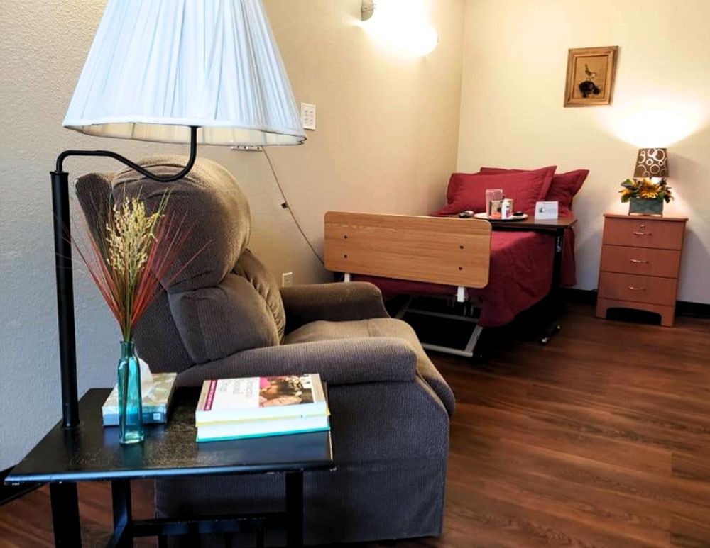 A cozy bedroom with a comfortable chair and bedside table.