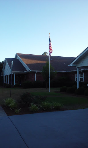 A peaceful residential building with an American flag displayed in the front yard.