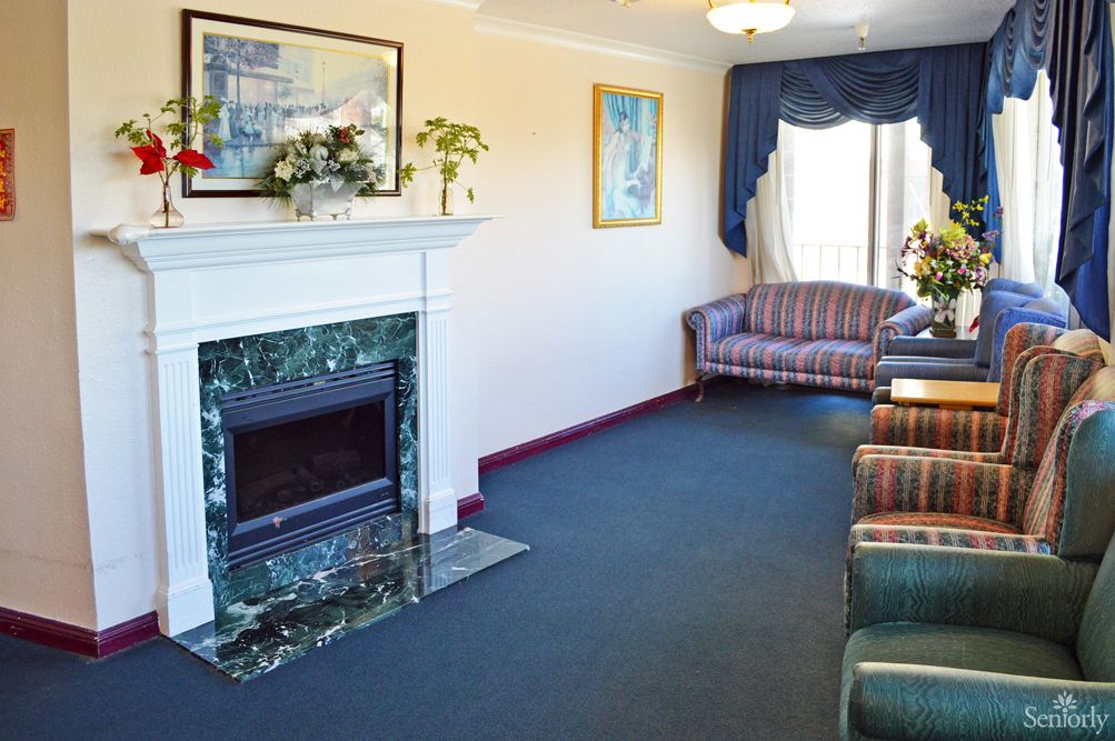 A cozy living room featuring a marble fireplace, comfortable sofas, and elegant decor.