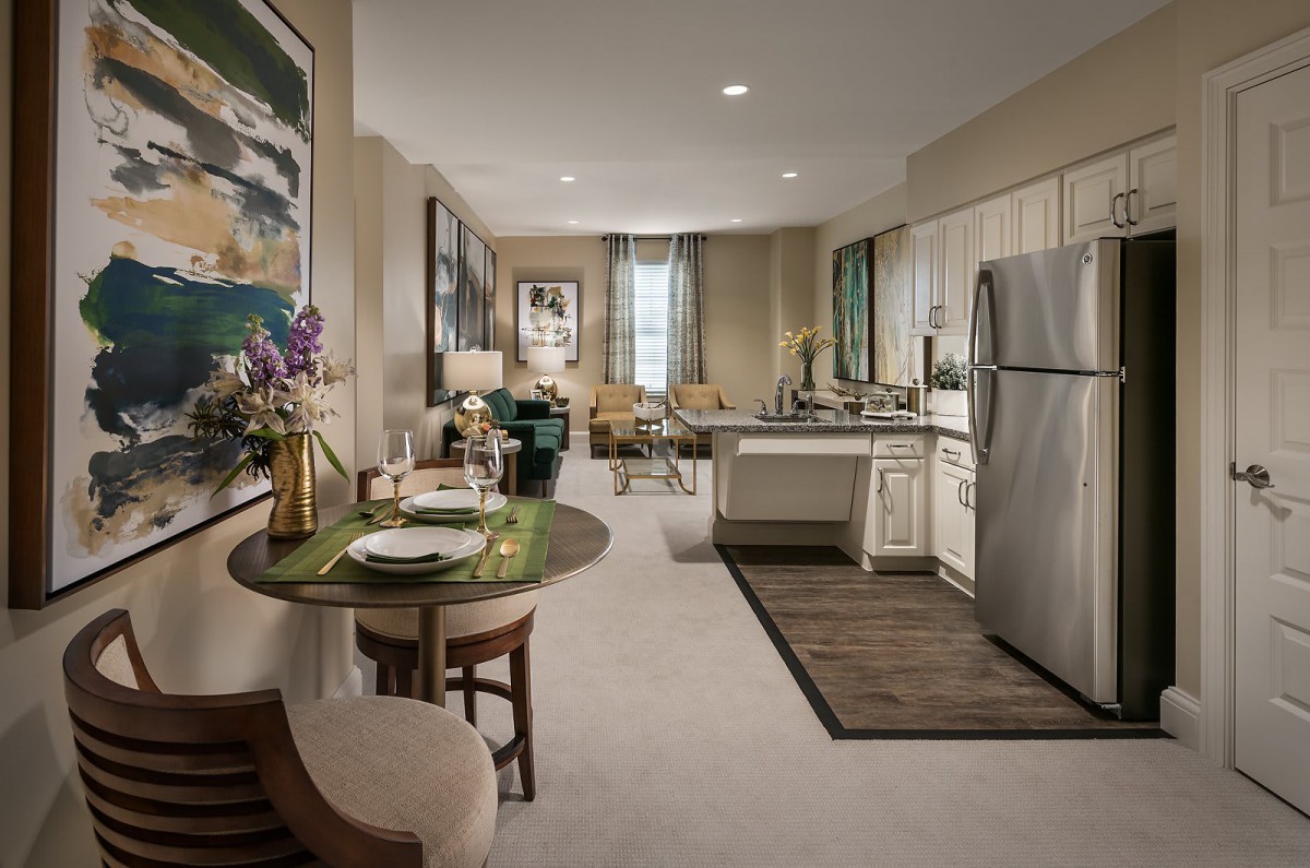 A modern open-concept apartment with a combined living room, kitchen, and dining area.