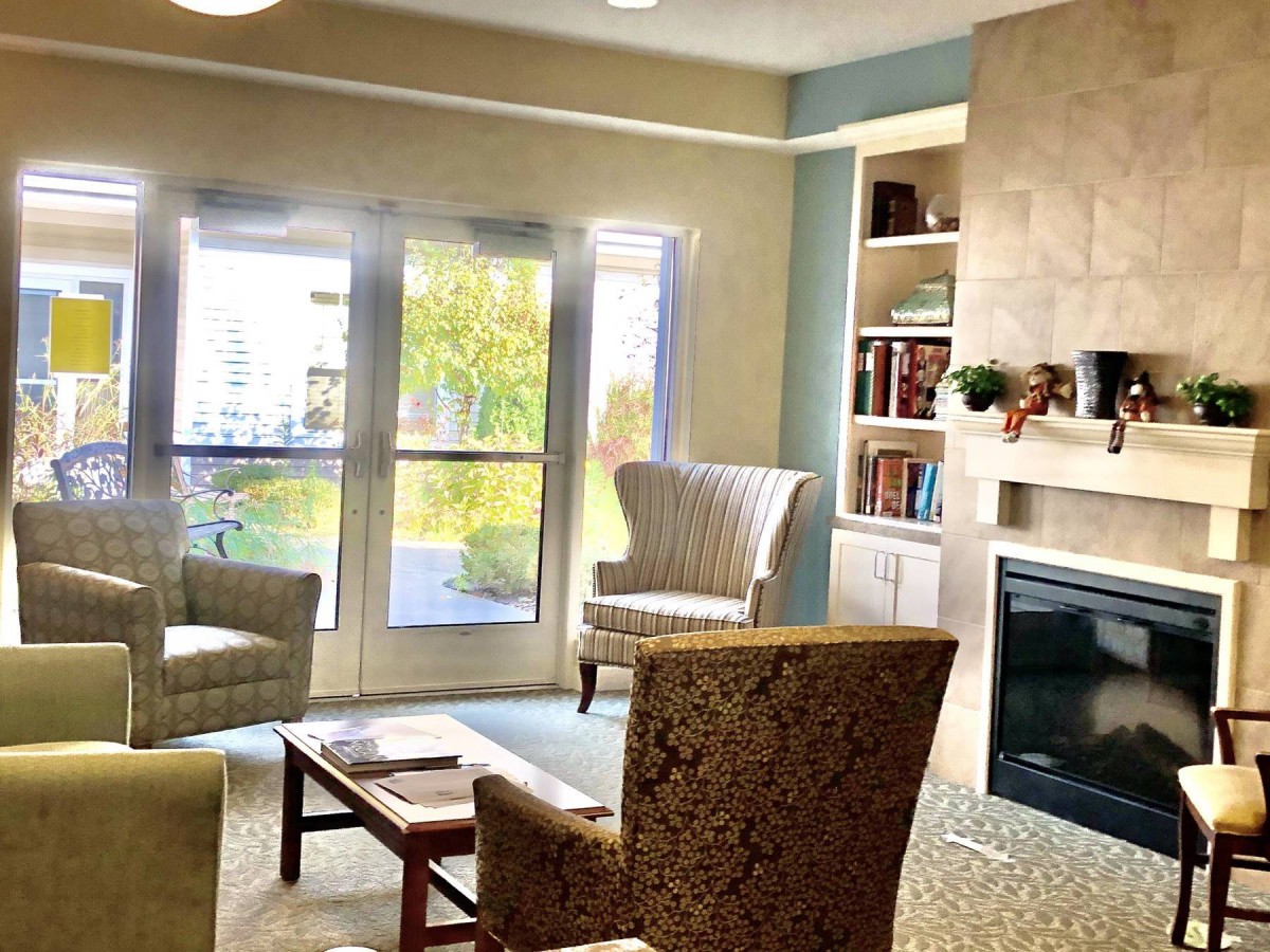 A cozy living room with comfortable seating, a fireplace, and large windows.