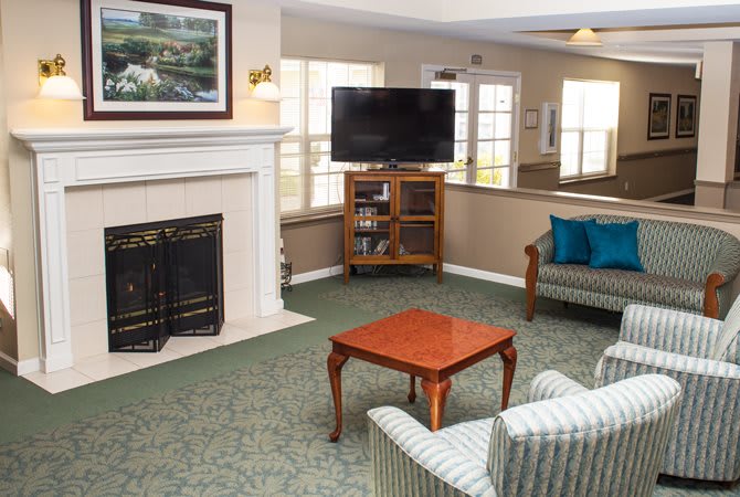 A cozy living room with a fireplace, television, and comfortable seating.