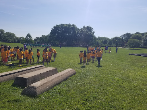 A group of children in yellow shirts enjoying outdoor activities on a sunny day.