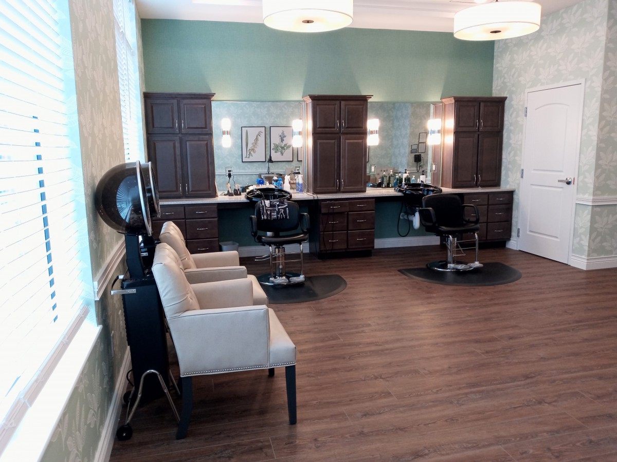 A modern beauty salon interior with styling stations, chairs, and mirrors.