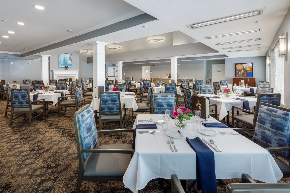 An elegant dining area with neatly arranged tables and chairs, set for a meal.