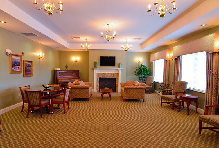 An elegant living room with sofas, a fireplace, and chandeliers.