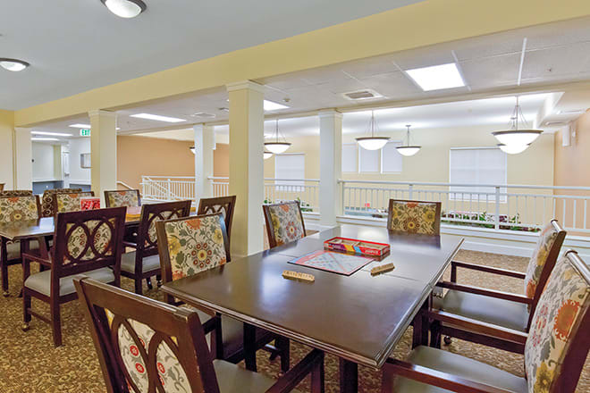 A dining area featuring a large table and chairs, with warm lighting.