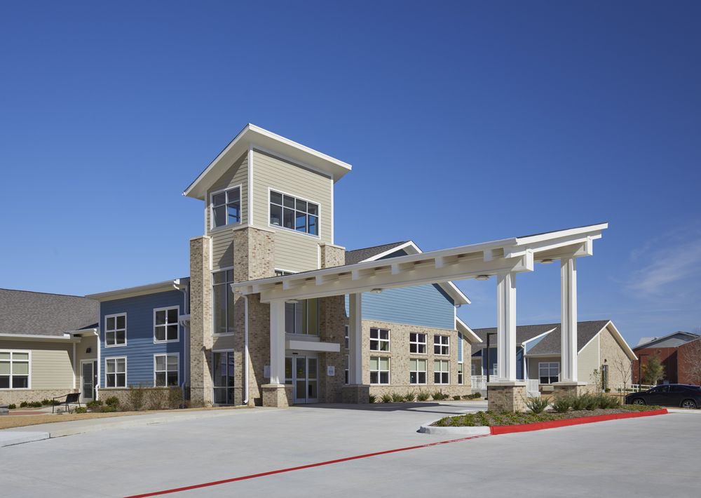 A modern building with a prominent entrance and clear blue sky in the background.