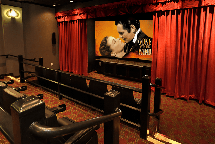 An empty cinema room showcasing the classic film 'Gone with the Wind' on screen.