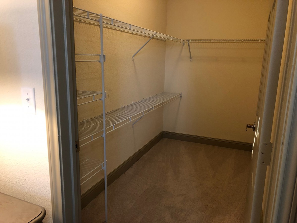 An empty walk-in closet with shelving and hangers.