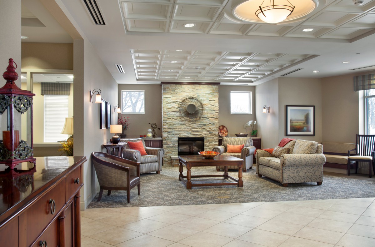A cozy and modern living room with comfortable seating around a fireplace.