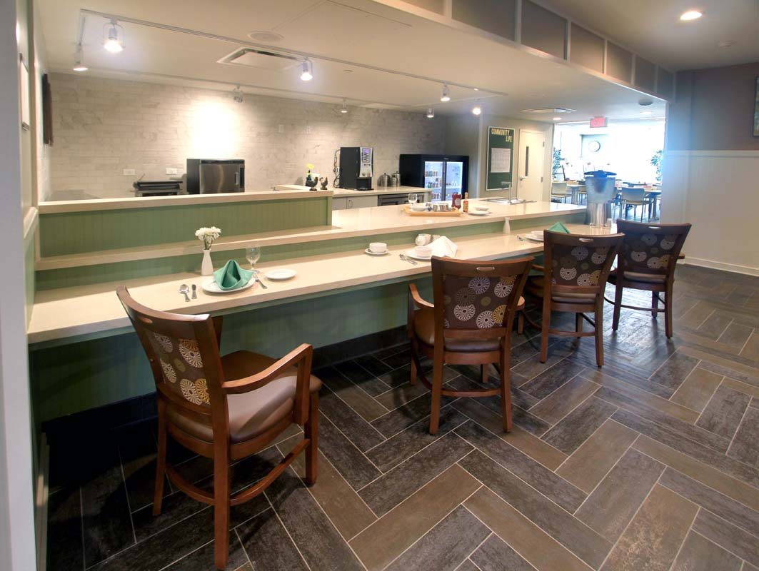 A modern cafe interior featuring a counter with several chairs.