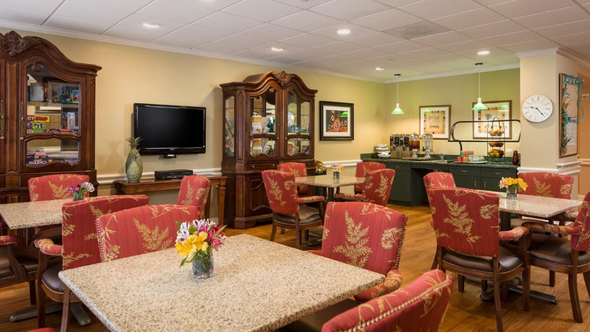 A cozy dining area featuring elegant furniture, a television, and decorative elements.