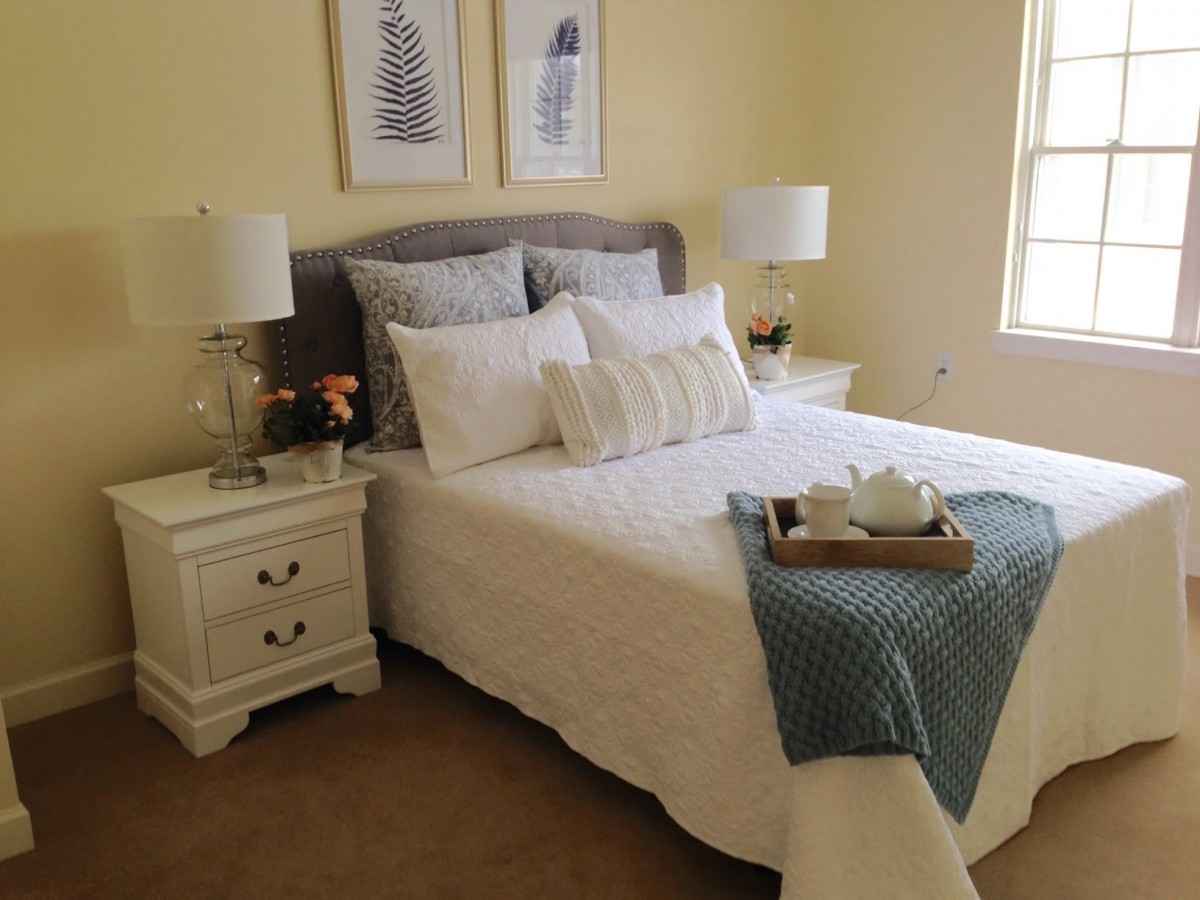 A cozy and stylish bedroom with neatly arranged bedding and elegant decor.