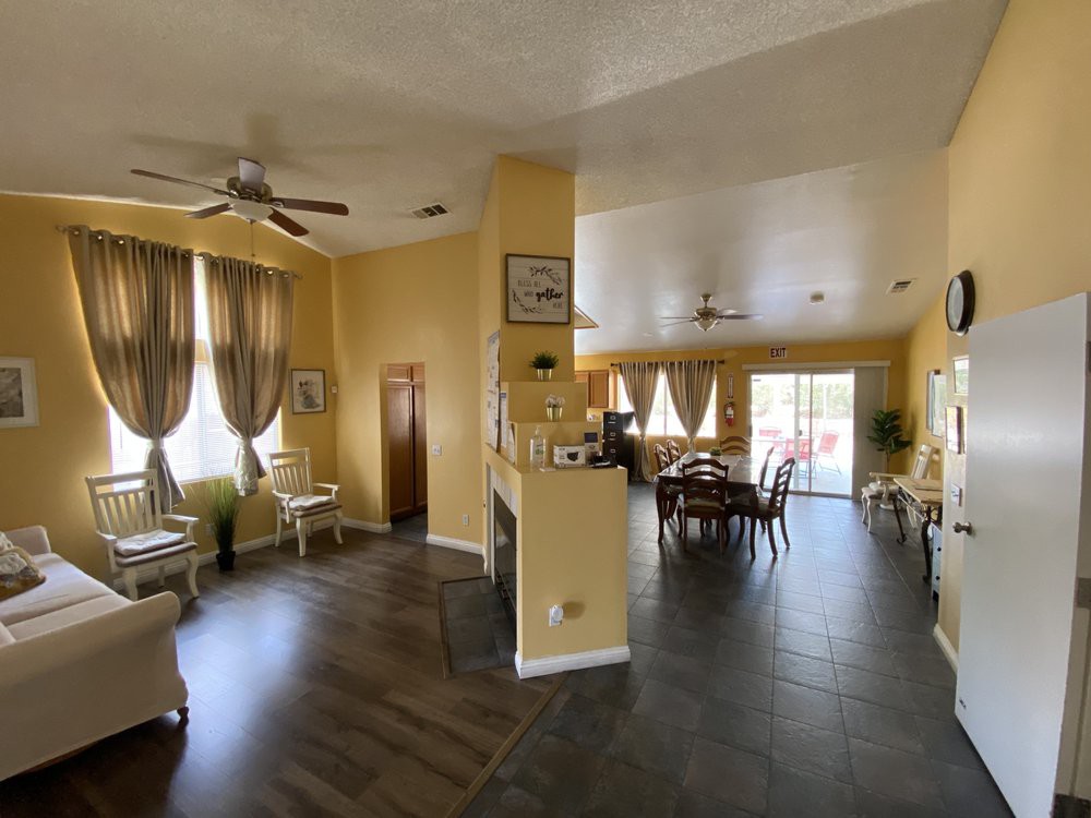 A spacious open floor plan living room and dining area with elegant decor, featuring wood flooring and abundant natural light.
