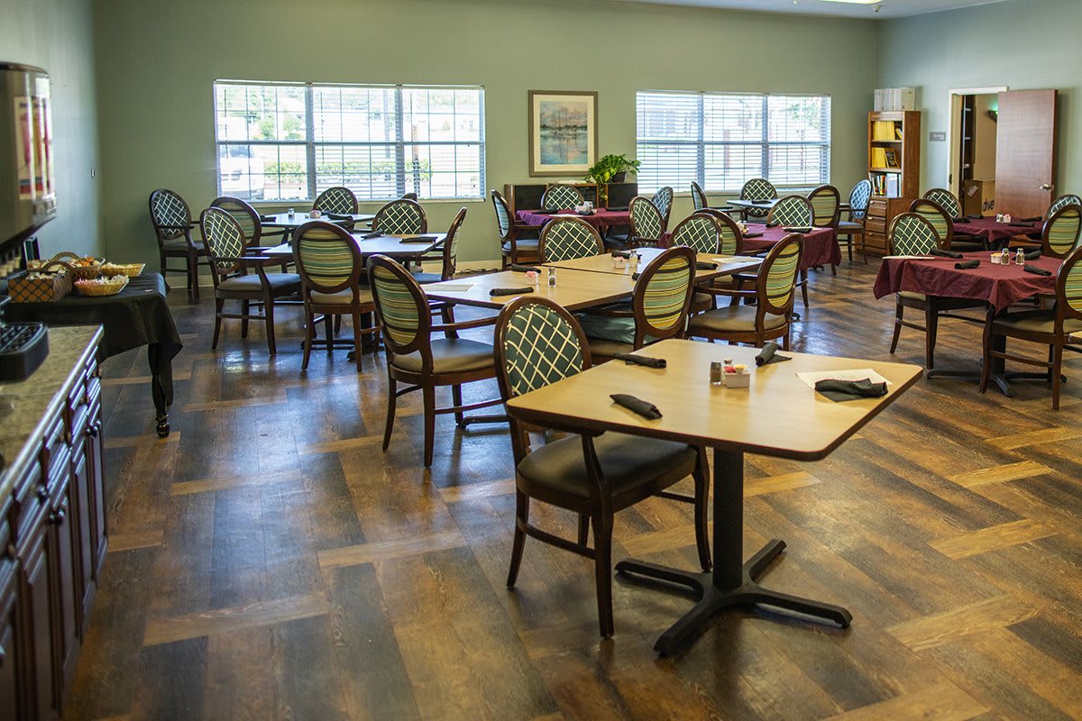 An empty dining room with neatly arranged tables and chairs.