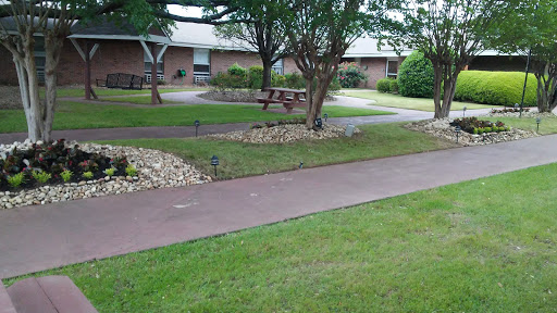 A peaceful park area featuring a winding pathway, lush greenery, and comfortable benches for relaxation.