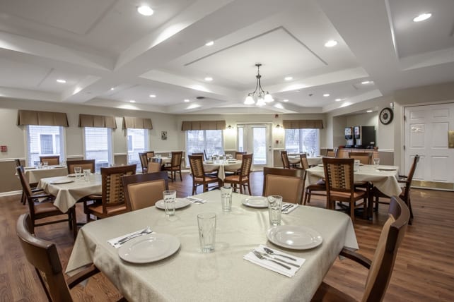 An elegant dining room with neatly set tables and comfortable chairs.