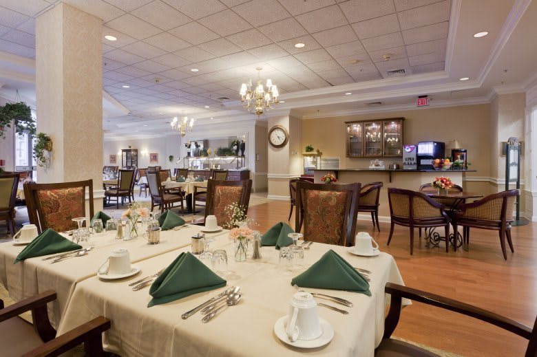 A well-decorated dining area with set tables and elegant chandeliers.