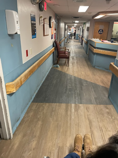 A view of a hospital corridor featuring a waiting area and medical environment.