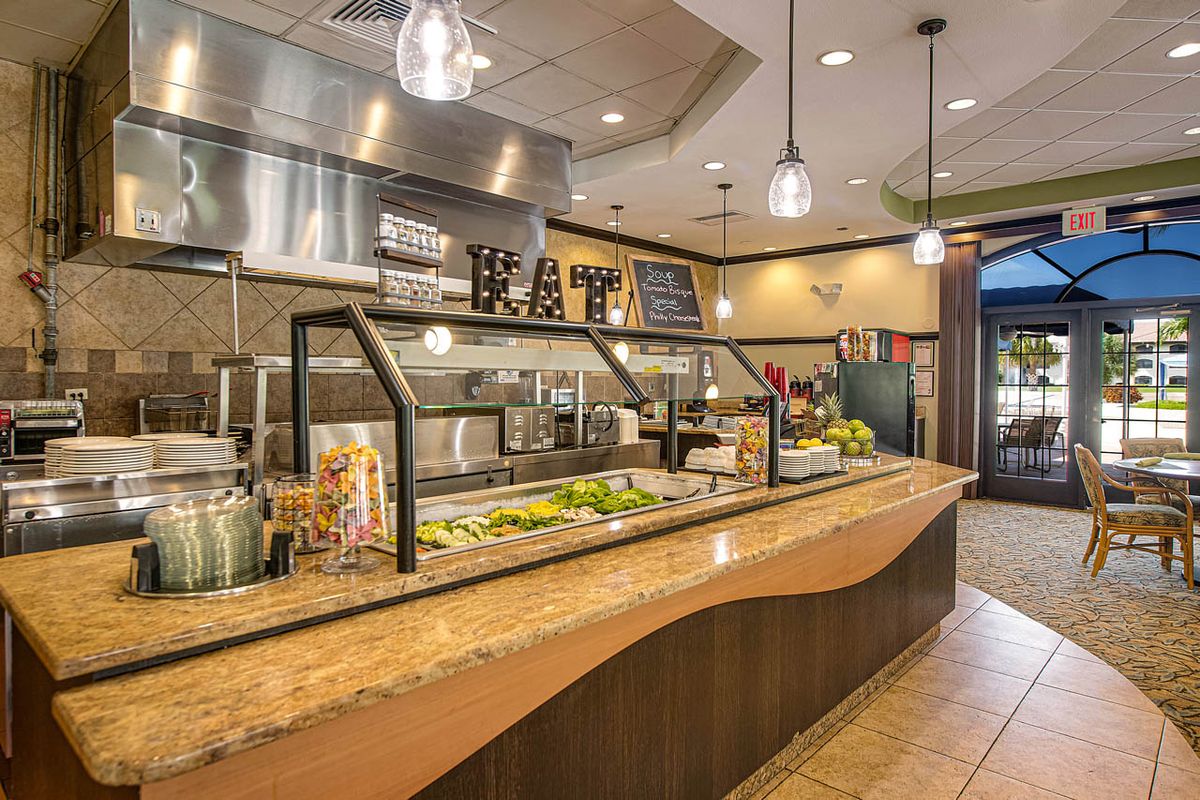 A modern restaurant interior featuring a buffet-style salad bar with various fresh ingredients.