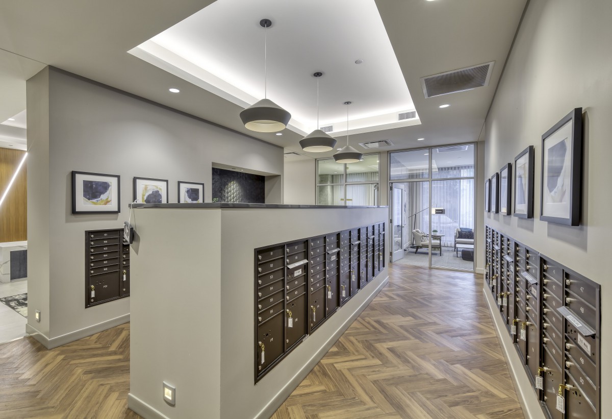 A modern mailroom with rows of mailboxes and stylish lighting.