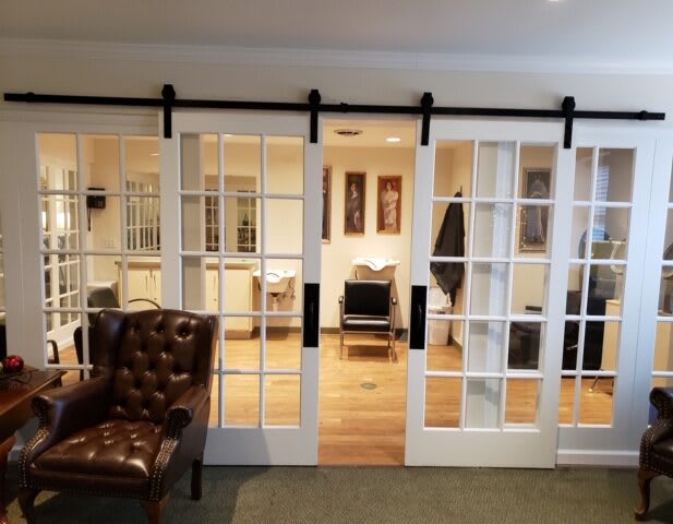 A cozy office interior with glass sliding doors and a leather armchair.