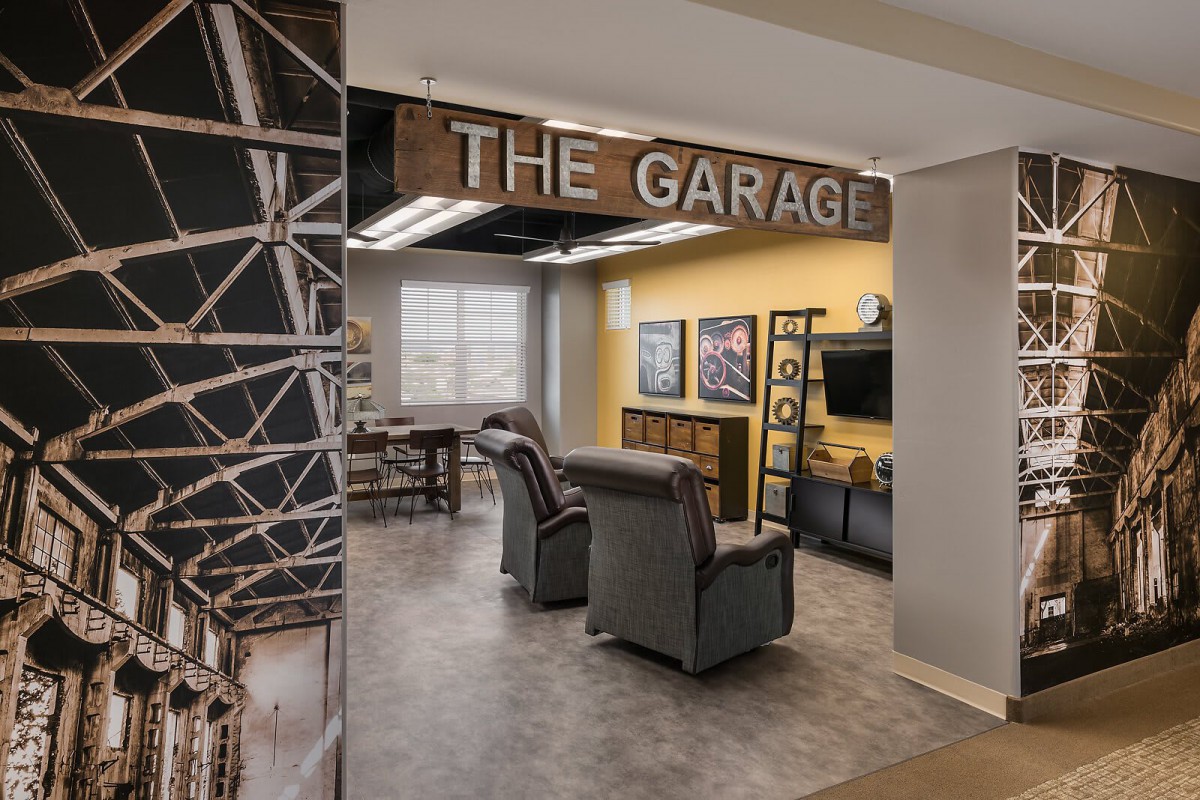 A cozy lounge area labeled 'The Garage' with comfortable seating and a TV.