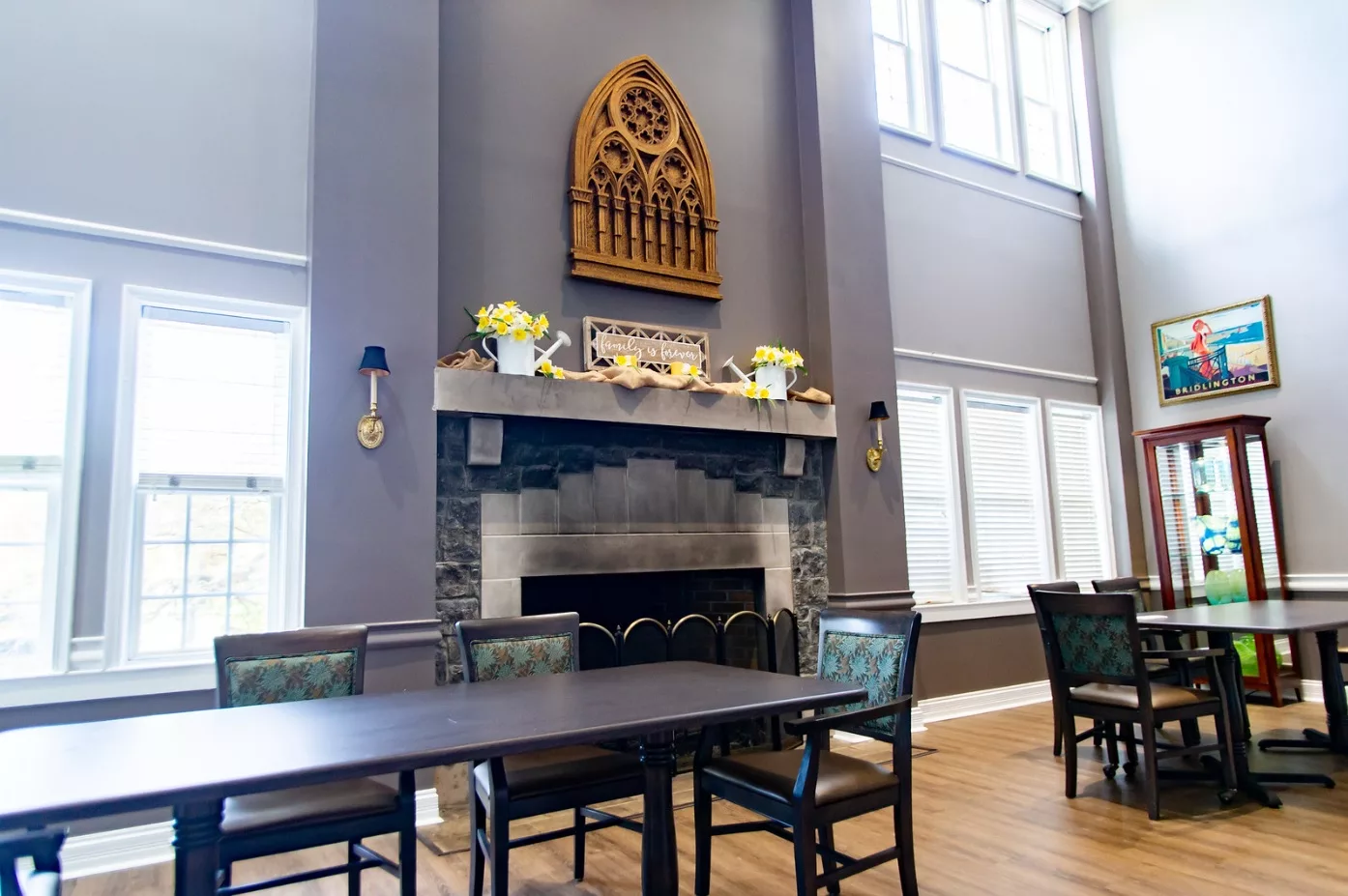 A dining area featuring a central fireplace with decorative elements and ample natural light.