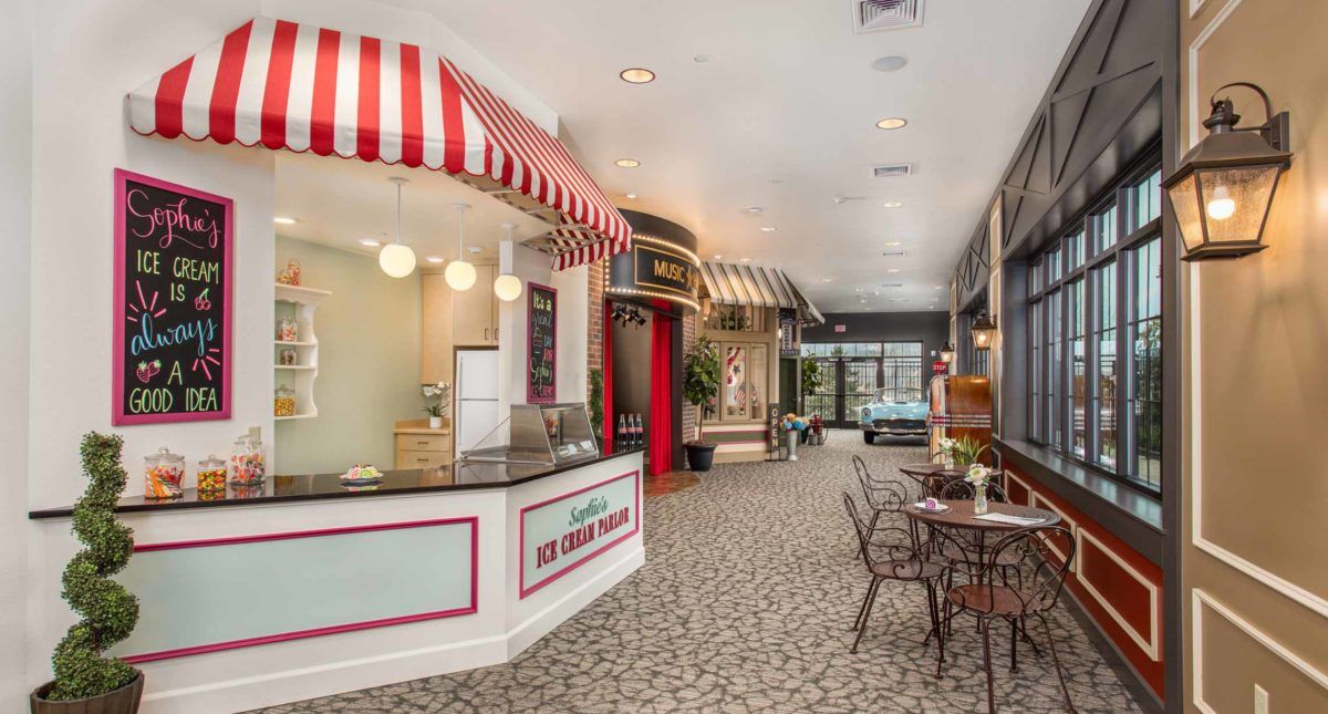 A vintage-style cafe with an ice cream parlor theme, featuring striped awnings and classic seating arrangements.