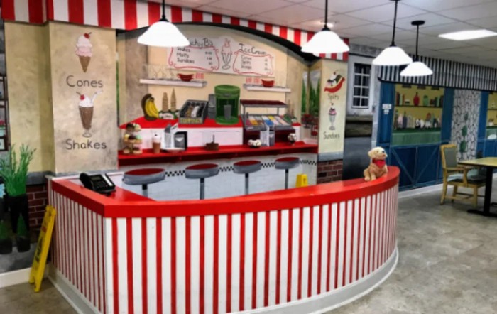 A retro-style ice cream shop with a red and white striped counter and stools.