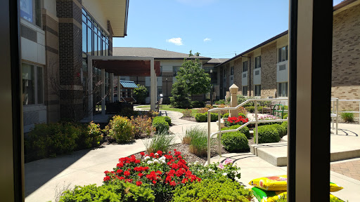 A beautifully landscaped courtyard featuring vibrant flowers and a winding pathway.