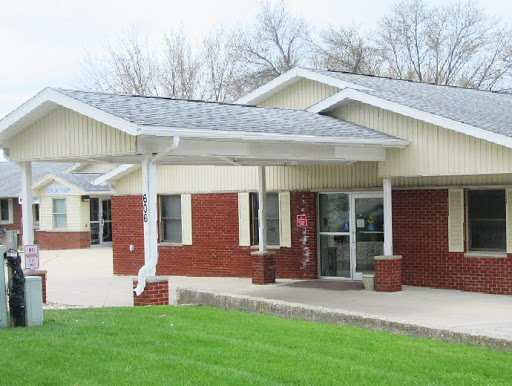 A modern single-story building featuring a combination of brick and siding with a landscaped front yard.