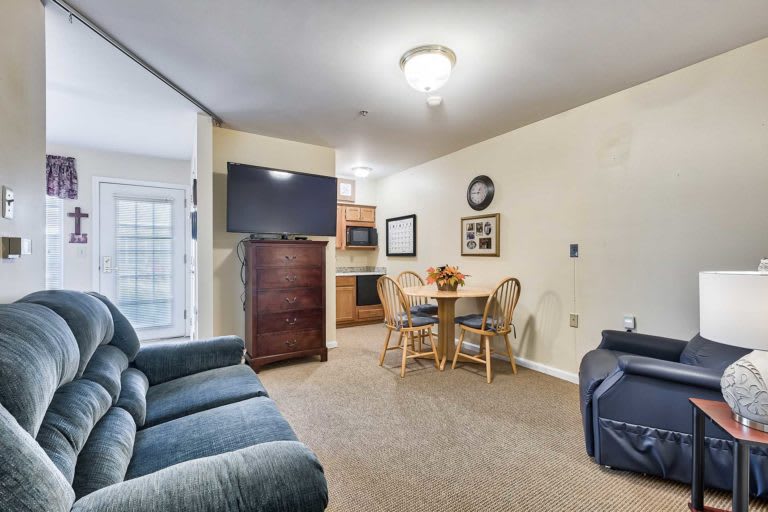 A cozy living space with a sofa, dining area, and kitchen in view.