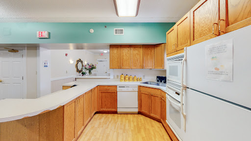 A spacious and modern kitchen featuring wooden cabinetry and white appliances, designed for functionality and style.