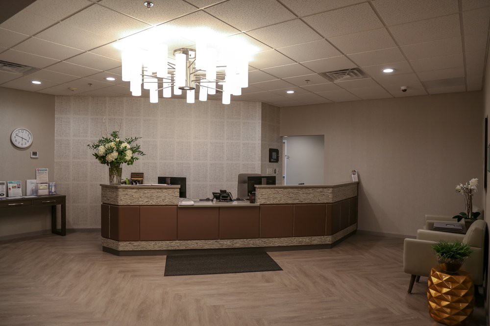 A modern office reception area with a central desk and decorative lighting.