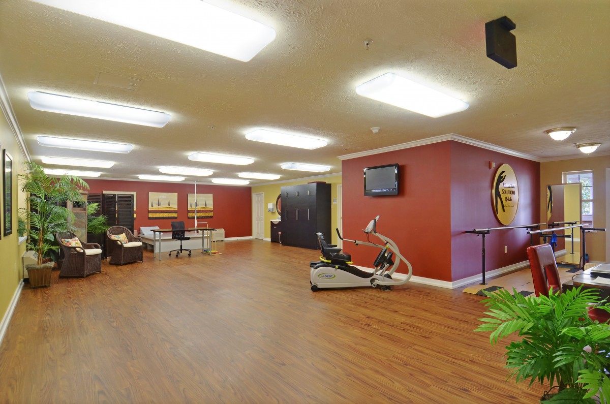 A modern, spacious gym interior with exercise equipment and wooden floors.