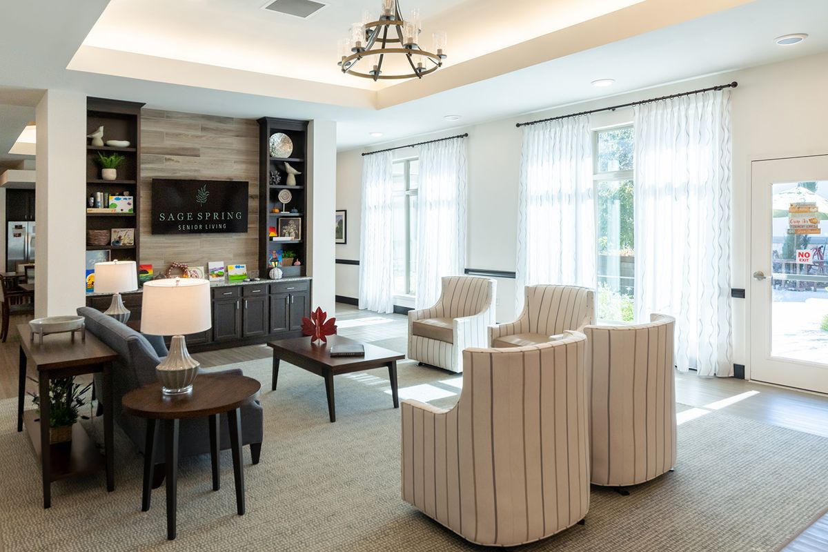 A modern and elegant living room with natural lighting, featuring stylish armchairs and a central coffee table.
