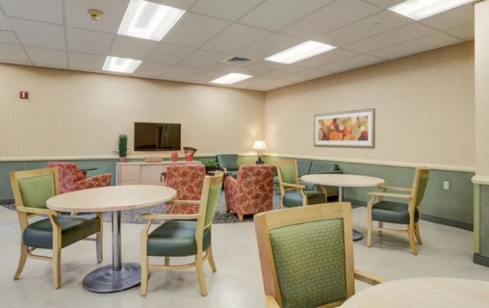 A well-lit waiting room with comfortable seating and tables.